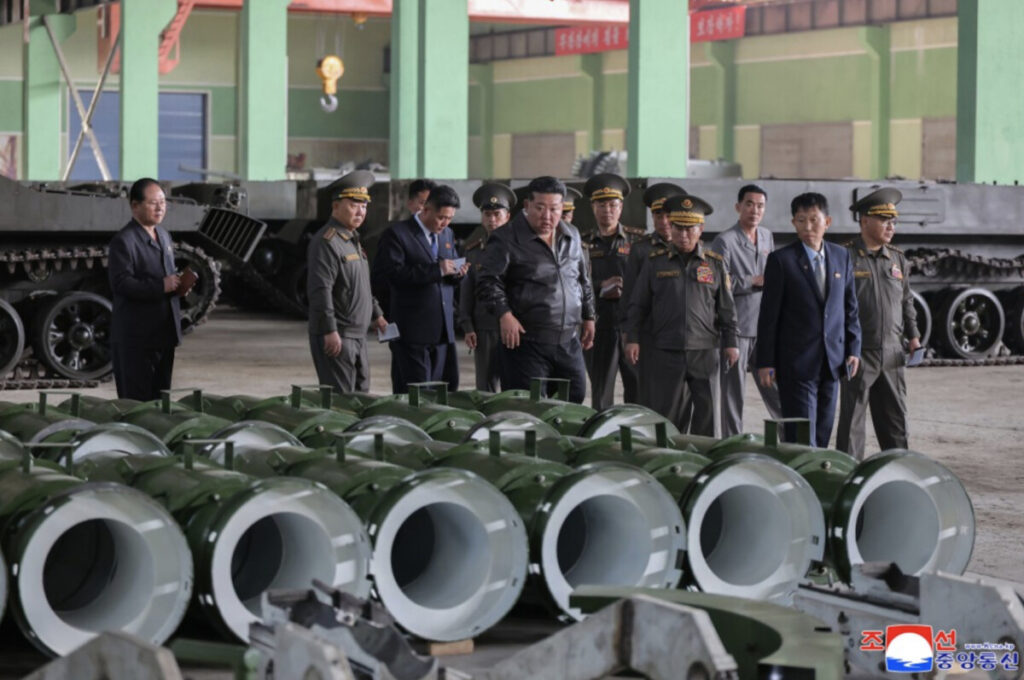 Screenshot 20260510 at 2 54 14 pm | nk insider group of military officers in uniform inspect rows of large green cylindrical components inside an industrial facility tanks are in the background